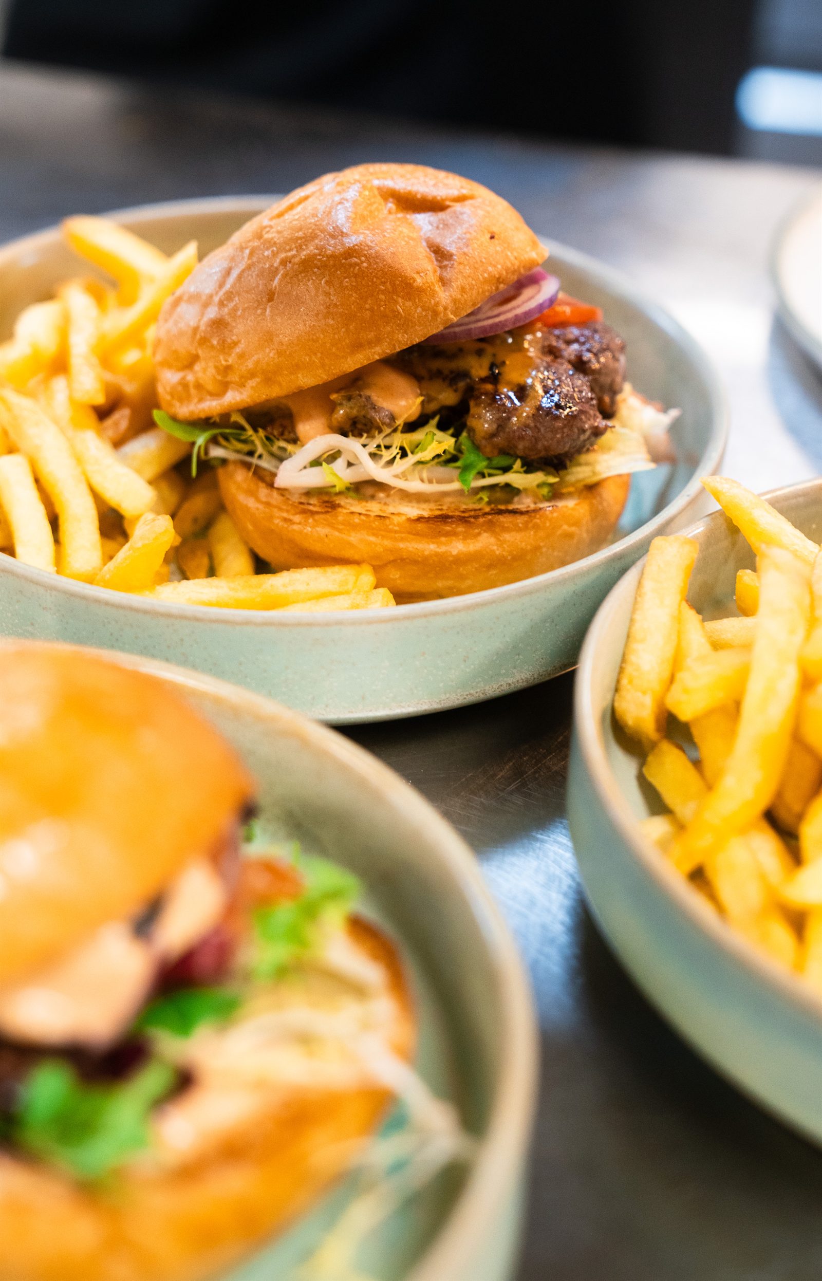 House burgers with golden fries on sage plates